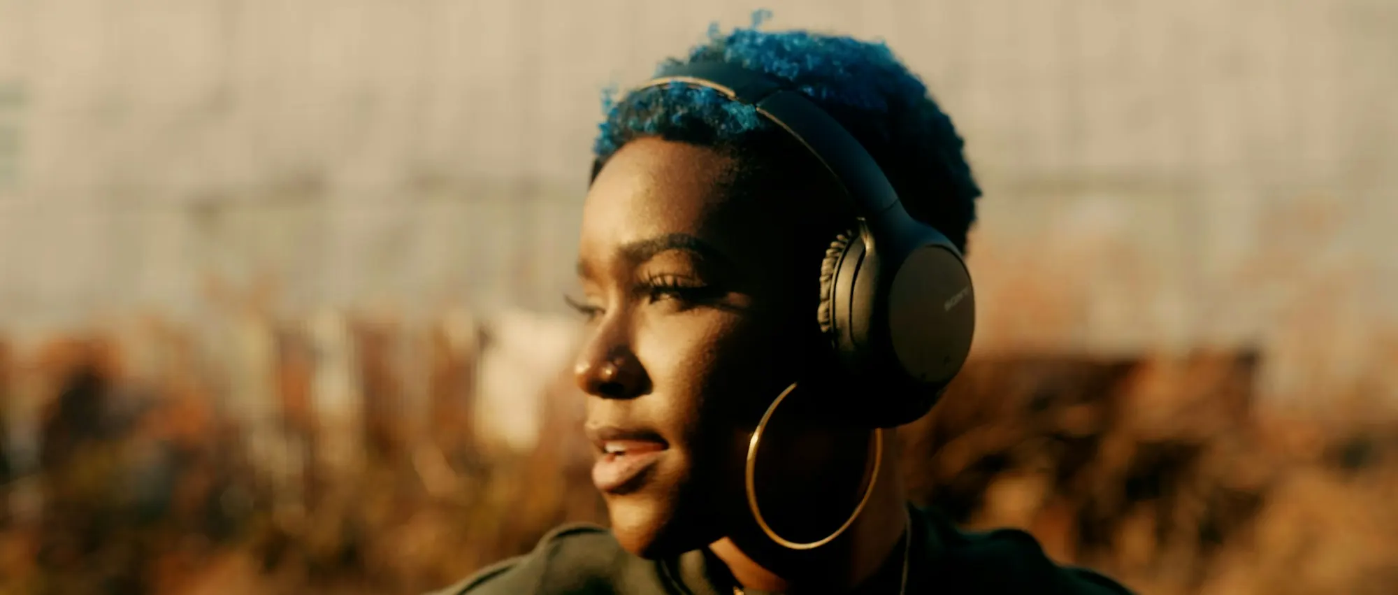 Portrait d’une femme qui écoute avec un casque, dans une lumière dorée